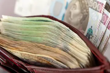Portfel pełen banknotów, od zielonych po brązowe. Czy to wystarczy na pensję minimalną?