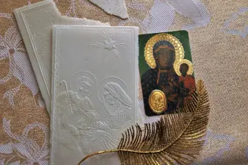 Opłatek z sceną narodzenia Jezusa, ikona Matki Boskiej z Dzieciątkiem i złoty liść. Symbolika modlitwy przed wieczerzą wigilijną.