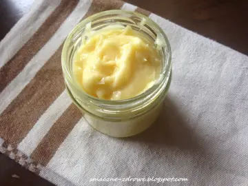 Domowy sos aioli w słoiczku, kremowy i puszysty, gotowy do podania.