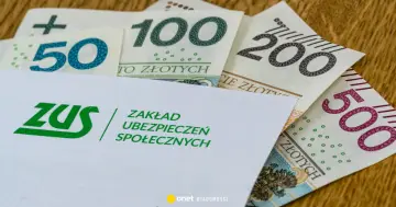 Koperta ZUS z napisem "Zakład Ubezpieczeń Społecznych" na tle polskich banknotów 50, 100, 200 i 500 zł. Symbolizuje świadczenie kompensacyjne.