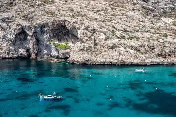 Malta, grudzień: turkusowa woda, skaliste klify i łodzie. Pogoda idealna na rejs.