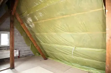 Na poddaszu rozłożona folia paroizolacyjna na drewnianych belkach, chroniąca przed wilgocią.