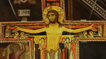 Starożytny krzyż św. Franciszka z malowanymi postaciami Jezusa, Maryi, Jana i aniołów.