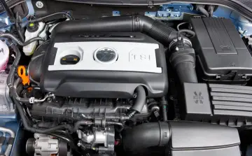 Silnik TSI, często chwalony w opiniach za dynamikę i oszczędność. Widok na pokrywę silnika z logo VW.