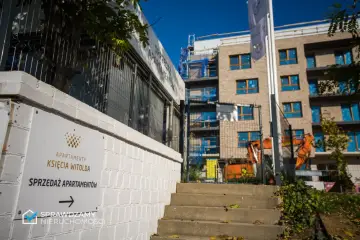 Budowa apartamentów z tablicą "Apartamenty Księcia Witolda" i koparkami.