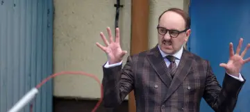 Adam Woronowicz w garniturze w kratę, z gestykulacją, jakby opowiadał o swoich filmach.