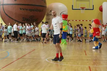 Trener z mikrofonem i dzieci w hali sportowej. Czy uda się znaleźć wszystkich uczestników?