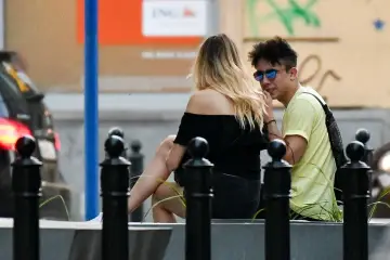 Dawid Kwiatkowski i jego partnerka siedzą obok siebie, rozmawiając.