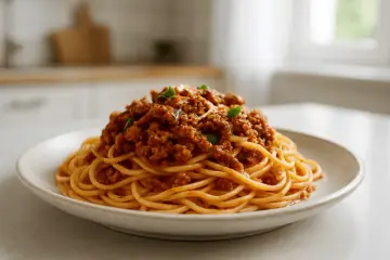 Porcja spaghetti bolognese, przygotowana według oryginalnego przepisu, z bogatym sosem mięsnym i świeżą bazylią.