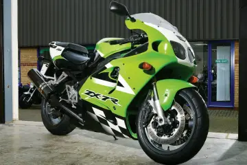 Zielony Kawasaki ZXR 750 z czarno-białą szachownicą na owiewce, gotowy do jazdy.
