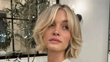 Kobieta z blond włosami w stylu cienkie włosy bob warstwowy cieniowany, z delikatnymi falami i grzywką na bok.