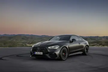 Mroczny Mercedes CLE 53 AMG na tle górskiego krajobrazu o zachodzie słońca.
