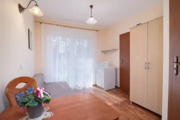 Willa Gwiazda Północy: przytulny pokój z kanapą, szafą, lodówką i stołem.