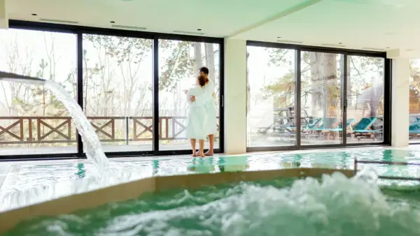 Pareja abrazada en un spa, disfrutando de la piscina y la vista. Así se hace en un spa: relajación y conexión.