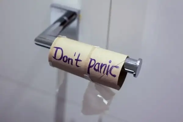 Pusta rolka po papierze toaletowym z napisem "Don't Panic" (Nie panikuj). Może to być metafora sytuacji, w której brakuje czegoś, ale nie ma powodu do zmartwień, jak np. w przypadku problemów żołądkowych, gdzie Tasectan mógłby pomóc.