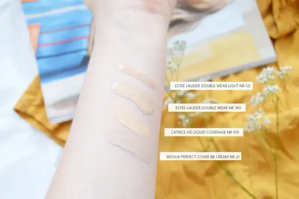Smugi podkładów na przedramieniu: Estee Lauder, Catrice i Missha.