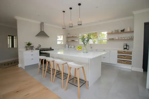 Une cuisine moderne et lumineuse, parfaite pour **créer sa cuisine** de rêve. Îlot central blanc, tabourets design, et rangements astucieux.