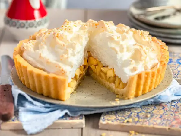 Ein saftiger Apfelkuchen mit Baiserhaube, dessen goldbrauner Boden und die fluffige, leicht gebräunte Haube zum Reinbeißen einladen.