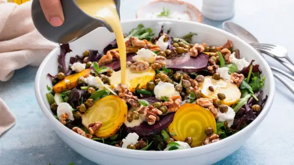 Una ensalada vibrante con remolachas, queso de cabra y nueces, bañada con deliciosas salsas para ensaladas.