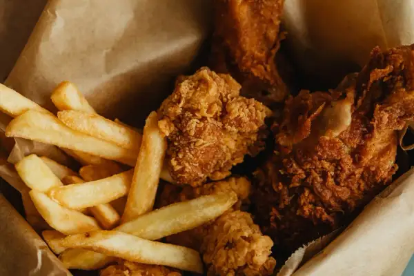 Krispiga chicken nuggets och gyllene pommes frites i en brun papperspåse. En klassisk kombination för en snabb och god måltid.