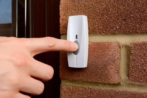 Main tenant appuie sur le bouton pour installer une sonnette sans fil.
