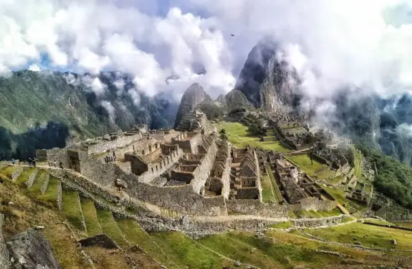 Niesamowita wycieczka do Machu Picchu. Ruiny Inków w chmurach, otoczone zielonymi wzgórzami i majestatycznymi szczytami Andów.