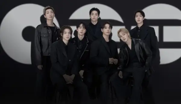 Die Mitglieder von BTS posieren in schicken schwarzen Outfits vor einem großen, stilisierten "GQ"-Logo.
