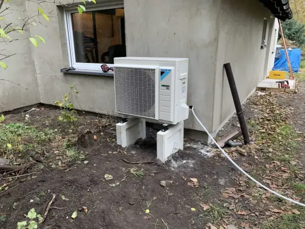 Nowoczesna pompa ciepła woda woda Daikin, zamontowana na zewnątrz budynku, gotowa do pracy.