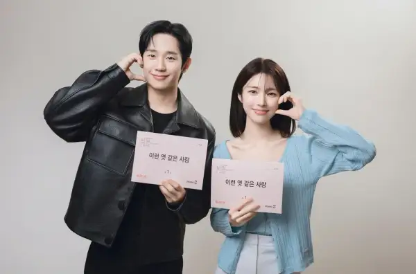 Jung Hae In und seine Kollegin halten Drehbücher für "A Love So Beautiful" und lächeln.