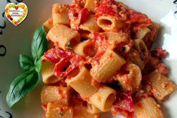 Un piatto di pasta con peperoni rossi e basilico fresco. Un'esplosione di sapori mediterranei.