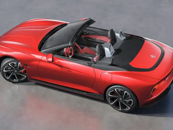 Czerwony MG Roadster z otwartym dachem, sportowe fotele i kierownica.