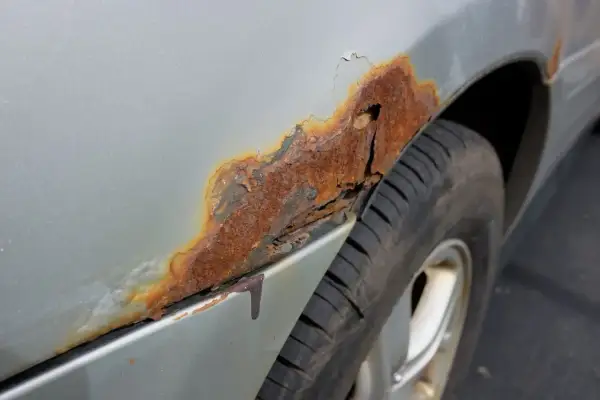 Starke Korrosion am Kotflügel eines Autos. Die Kosten für Rost entfernen am Auto können je nach Ausmaß variieren.