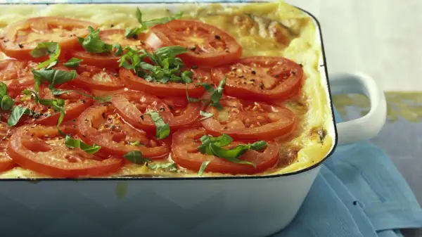 Herzhafte auberginen lasagne, überbacken mit Tomatenscheiben und frischem Basilikum, duftet verführerisch.