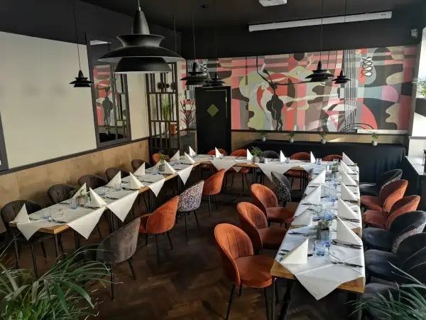 Elegancka sala bankietowa z nakrytymi stołami, idealna na wyjątkowe okazje. To może być najlepsza restauracja w Olsztynie.