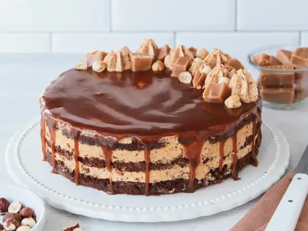 Schokoladenkuchen mit Karamellcreme und Nüssen, überzogen mit glänzender Schokoladenglasur. Eine köstliche Nuss Karamell Torte.