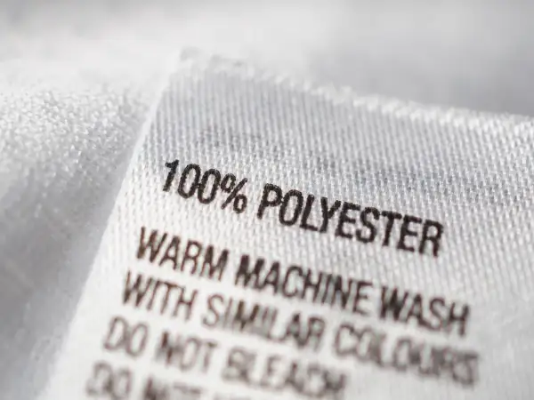 Etikett zeigt "100% POLYESTER". Ist Polyester gut? Ja, es ist pflegeleicht und langlebig.