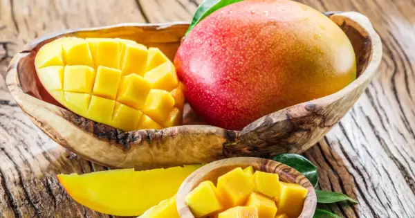 Dojrzałe mango w drewnianej misce, pokrojone w kostkę i plastry. Słodki owoc, który warto znać jego mango kcal.