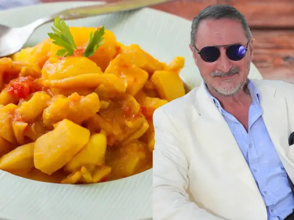 Un hombre con gafas de sol y traje blanco sonríe junto a un plato de papas con choco de la abuela, un guiso casero.
