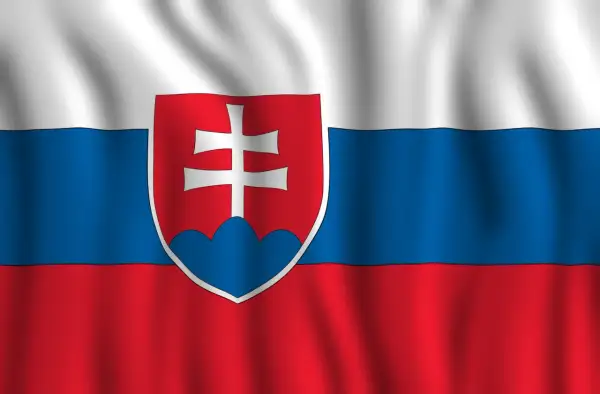 Flaga Słowacji powiewa na wietrze. Biało-niebiesko-czerwone pasy z godłem Słowacji, przedstawiającym podwójny krzyż na trzech wzgórzach.