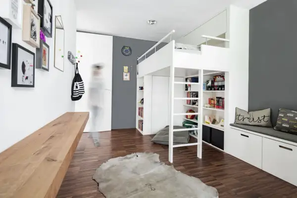 Cleverer Stauraum im Kinderzimmer: Hochbett mit integrierten Regalen und Schränken, DIY-Bank und Wandhaken für Ordnung.