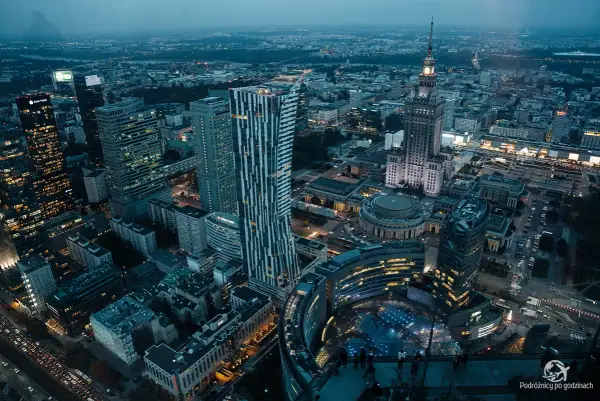 Widok z góry na nocną panoramę Warszawy, z wieżowcami i Pałacem Kultury. Marzysz o takich widokach? Kup bilety na Varso Tower!