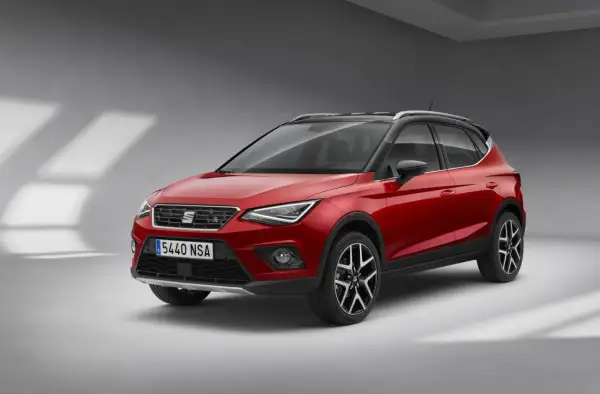 Czerwony Seat Arona z czarnym dachem, gotowy na miejskie przygody.