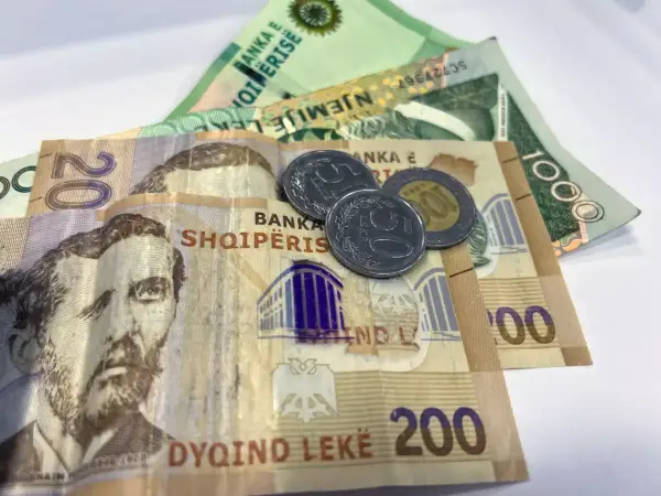 Banknoty i monety, które pokazują, jaka waluta w Albanii. Widoczne są nominały 20, 200 i 1000 leków.