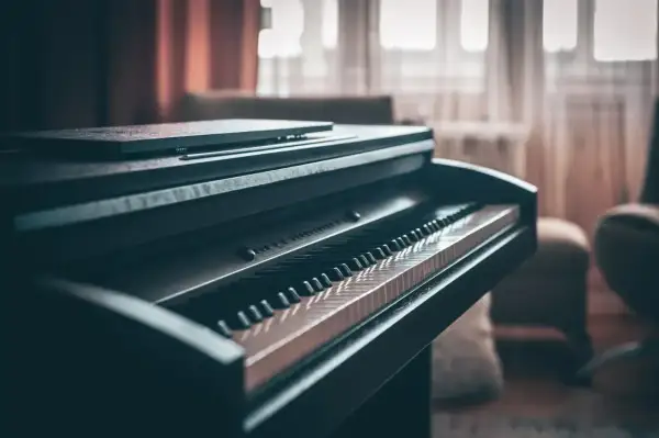 Ciemne pianino cyfrowe z klawiaturą w zbliżeniu. Zastanawiasz się, ile waży pianino? Ten instrument jest solidny.