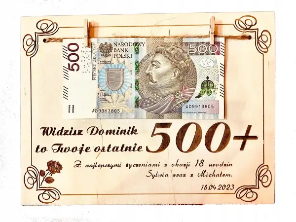 Drewniana tabliczka z banknotem 500 zł i napisem "500+".
