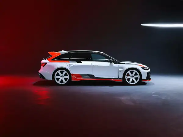 Białe Audi RS6 GT z pomarańczowymi akcentami i czarnymi pasami, gotowe do wyścigu.