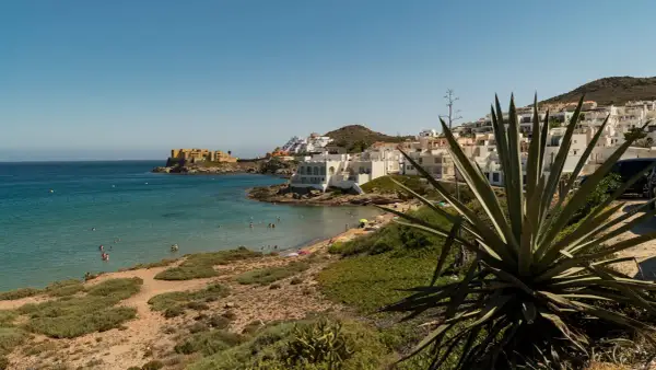Costa de San José con casas blancas, playa y mar turquesa. Ideal para ver qué ver en San José y disfrutar del sol.