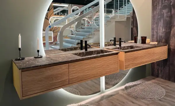 Une belle idée salle de bain marbre avec des meubles en bois et un grand miroir circulaire.