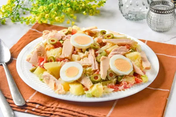 Sabrosa ensalada de patatas de la abuela con atún, huevo duro y aceitunas. Un plato casero que evoca recuerdos.