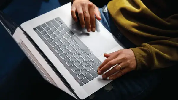 Person arbetar på laptop, kanske bokför bokföring för avdrag enskild firma.